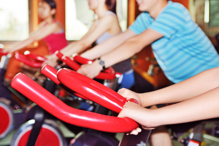 Beauty of woman indoor bycicle cycling in the gymの写真素材