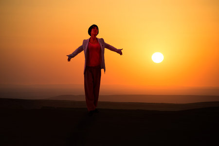 Young woman embrace nature on outdoor sunrise background.の写真素材