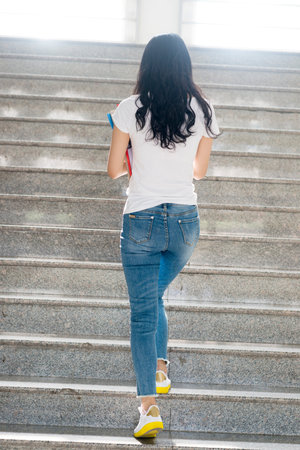 adult student walking at stairs in campus,rear view