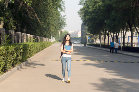 Girl carrying bag Walks in Campus Parkの写真素材