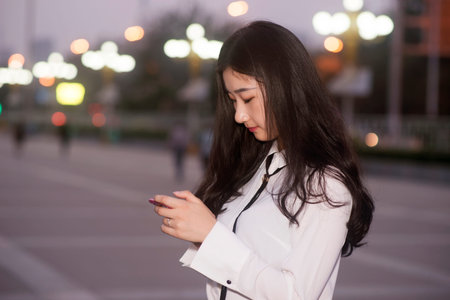 young woman use a mobile phone at nightの写真素材
