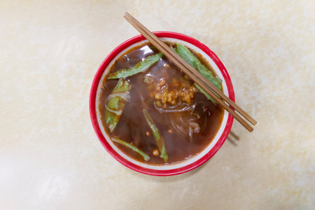 chinese noodles in a red bowl and chopsticks