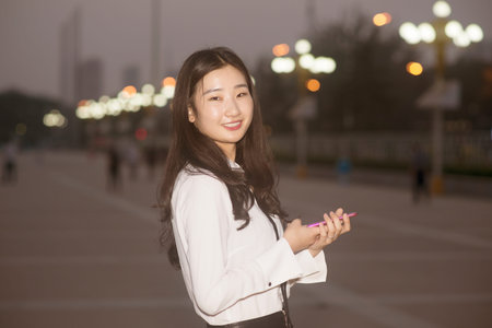 Portrait of a young beautiful woman on city streets at nightの写真素材