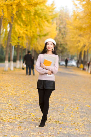 Portrait of a smiling pretty woman holding   books in handの写真素材