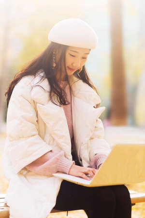 girl using laptops in the autumn at outdoorの写真素材