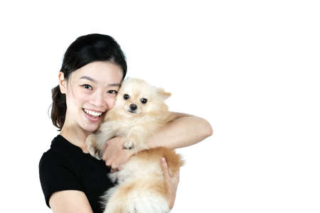 Asian girl holding Pomeranian dog, isolated on white backgroundの写真素材