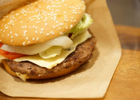 Beef burger on wood table, close-up image, focus on the beefの写真素材