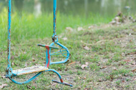 Stained and rusty horse swing on a playground parkの写真素材