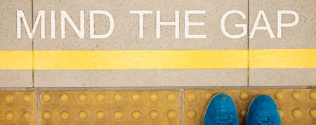 The sign " Mind the gap " painted on train station's platform edgeの写真素材