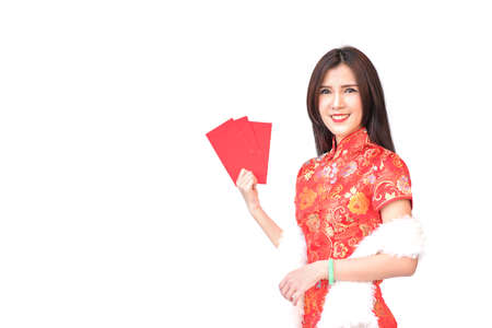 Beautiful Asian girl in Chinese qipao traditional dress, holding red money pockets or greeting card envelopes, Chinese new year concept, isolated on white backgroundの写真素材