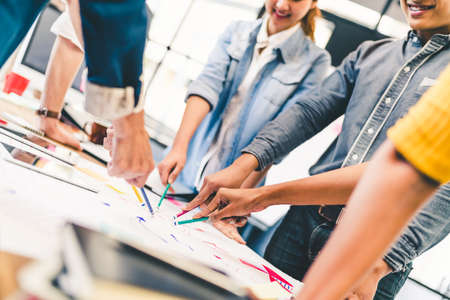 Group of multi-ethnic diverse team, business partner, or college students in project meeting at modern office or university. Five people pointing at diagram chart drawing. Creative or teamwork concept