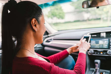 Woman using smartphone app on modern car. Mobile phone application, map navigation device technology, transportation, or crowdsourcing taxi conceptの写真素材
