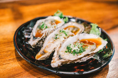 Three raw juicy oyster freshly opened and served on dish at Japanese restaurant. Fresh seafood famous menu. Healthy eating conceptの写真素材