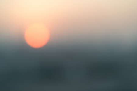 Blur abstract background of red sun going down in the city. Sunset scene or nature conceptの写真素材