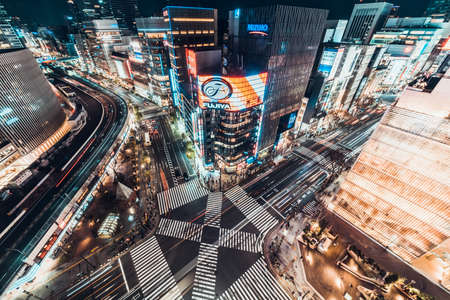 Tokyo, Japan - Jan 13, 2019: Cityscape aerial night view of Ginza zebra crosswalk road intersection with car traffic and pedestrians. Tokyo business and shopping district or Japanese city life conceptのeditorial素材