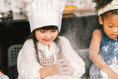 Cute mixed race and African American kid girls baking or cooking together in home kitchen. Education...