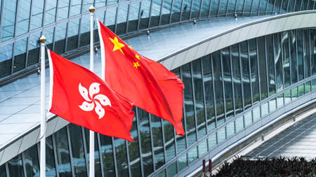 Hong Kong and mainland China national flags stand together with copy space. Nation symbol, countries political conflict conceptの写真素材
