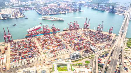 Hong Kong port industrial district with cargo container ship, cranes, car traffic on road and Stonecutters bridge. Logistic industry or freight transportation business conceptのeditorial素材