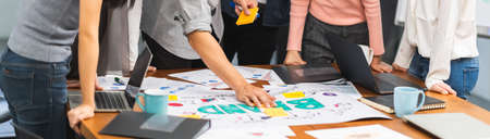 Young Asian creative team work together in business brand design project brainstorm meeting. Modern office, colleague coworker, marketing advertisement research or people teamwork concept. Banner sizeの写真素材