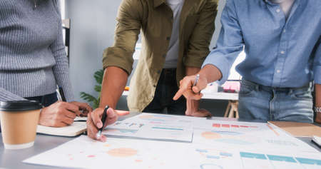 Young Asian business financial team work together in project brainstorm meeting. Cooperate teamwork, strategy planning, small business startup company, or office coworker collaborate conceptの写真素材