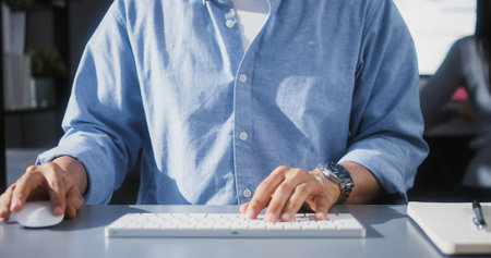 Asian man using desktop computer in home office, close up hand typing keyboard and mouse click....