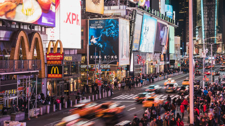 New York City, United States - Apr 4, 2019: Crowd of people walking, car and taxi traffic transportation, and advertisement at night in Times Square. American lifestyle or NYC travel landmark conceptのeditorial素材