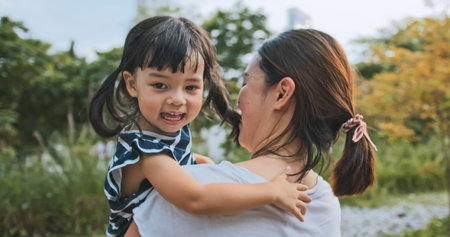 Young Asian mother hold cute daughter with smile. Mom kid love relationship or happy child girl...