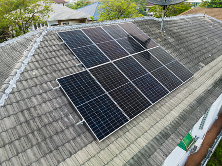 Solar grid panels on domestic house rooftop in Asia evening. Drone aerial view. Natural perpetual power technology, clean sustainable energy, zero waste lifestyle concept.の写真素材