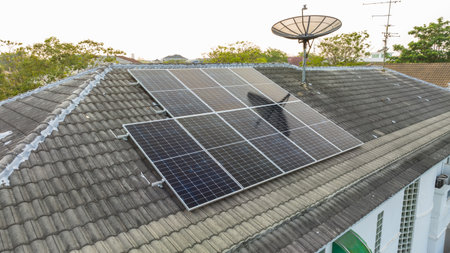 Solar grid panels on domestic house rooftop in Asia evening. Drone aerial view. Natural perpetual power technology, clean sustainable energy, zero waste lifestyle concept.の写真素材