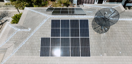 Solar grid panels on domestic house rooftop in Asia on sunny summer day. Drone aerial view. Natural perpetual power technology, clean sustainable energy, zero waste lifestyle concept.の写真素材