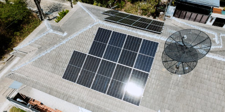 Solar grid panels on domestic house rooftop in Asia on sunny summer day. Drone aerial view. Natural perpetual power technology, clean sustainable energy, zero waste lifestyle concept.の写真素材
