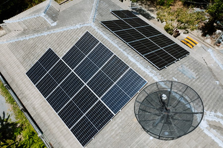 Solar grid panels on domestic house rooftop in Asia on sunny summer day. Drone aerial view. Natural perpetual power technology, clean sustainable energy, zero waste lifestyle concept.の写真素材
