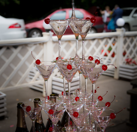 Pyramid of glasses of champagne cocktail with a cherry on the wedding ceremonyの写真素材