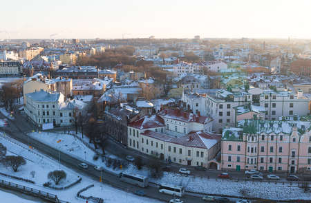 panoramic view of the snow-covered Vyborg with colorful houses roofs on the banks of the river embankment was a bright sunny dayの写真素材