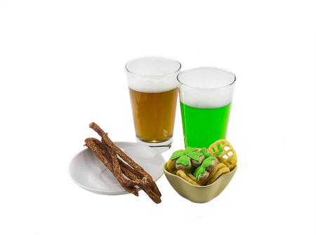 Two glasses of beer green camp with clover with delicious sausage on a snack on a white background. Feast of St. Patrick's Dayの写真素材
