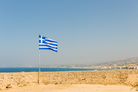 Rethymnon Greece Crete Island old Citadel Fort Fortezza fortress wall develops Greek flag on the background of the Mediterranean Seaの写真素材
