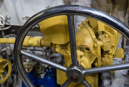 Fragment of an old metal big valve of the hand wheel a smooth shiny industrial backgroundの写真素材
