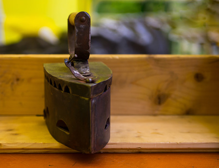 Antique iron with coal feeding on a wooden table close-upの写真素材