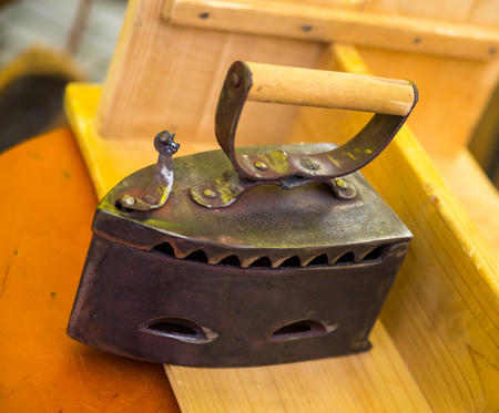 traditional iron charcoal heavy metal household element on a wooden backgroundの写真素材