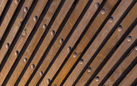 brown natural background. Wood texture inclined lines perspective perspective vertical metallic rivets industrial patternの写真素材