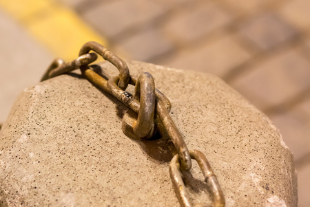 part of an iron chain on a stone surface, urban texture. grunge metal industrial backgroundの写真素材