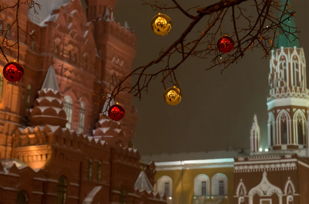 Red golden yellow ball on the tree Christmas decoration on the background of the Kremlin tower of Moscow and the historic museum in the evening lightの写真素材