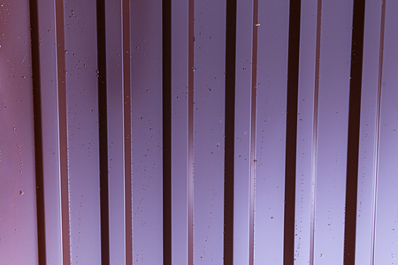 vertical metallic profile pattern lilac red galvanized surface covered with drops of dew rain industrial background base ribbedの写真素材