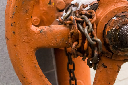 old chain painted winded with chipped links twist the valve most of the industrial background base closed locked circle on a blurred stone baseの写真素材
