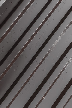 iron dark profile ribbed base building part of the roof diagonal dark pattern with drops of water...