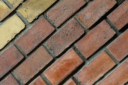 set brick row of stones terracotta yellow diagonal pattern close-up gray seam separated blocks urban...