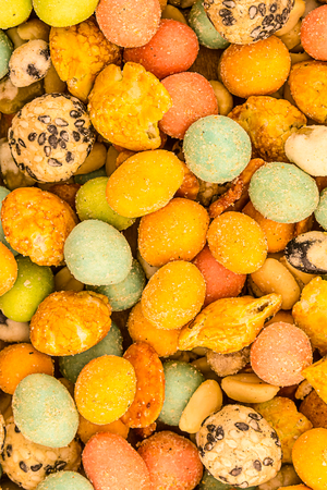 asian snacks glazed sharp snack multicolored yellow pink dragee nut snack background edible designの写真素材