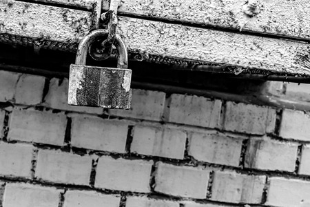 gray urban background toning closed hinged iron lock on brick wall background close-up of grunge baseの写真素材