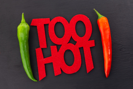 inscription Too Hot hot chili pepper message poster parallel chili pod red green frame on black form bright messageの写真素材