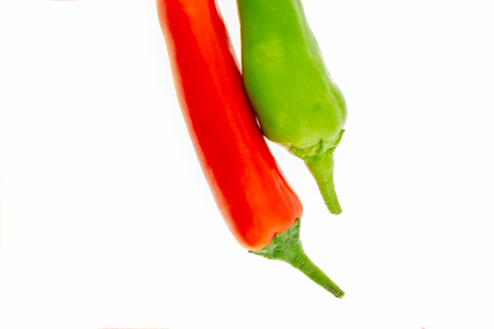 red green pepper spicy couple of vegetables end pod stalk on a white isolated backgroundの写真素材